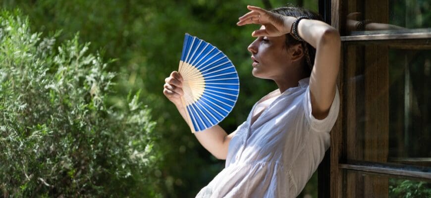 Young,Woman,Suffering,Heatstroke,Outdoors,Using,Fan,To,Get,Fresh